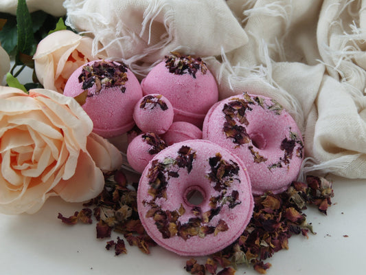 A pink Rose Petal Bath Bomb with dried rose petals visible on its surface.